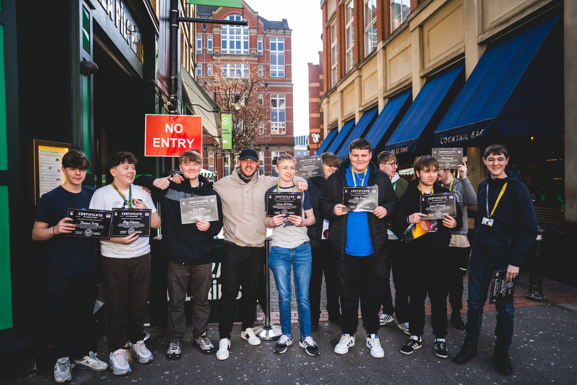 Group of students with certificates outside Pizza Pilgrims